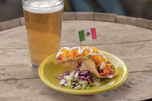 Our most popular taco! Tinga taco, topped with cheddar cheese, lettuce, tomato and crema. Served along side with a beer.