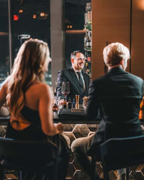 Two persons sitting next to a bar