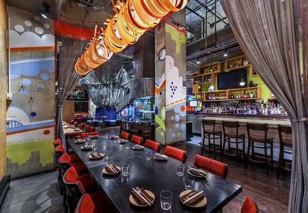 long dining table with artistic orange and red light fixtures