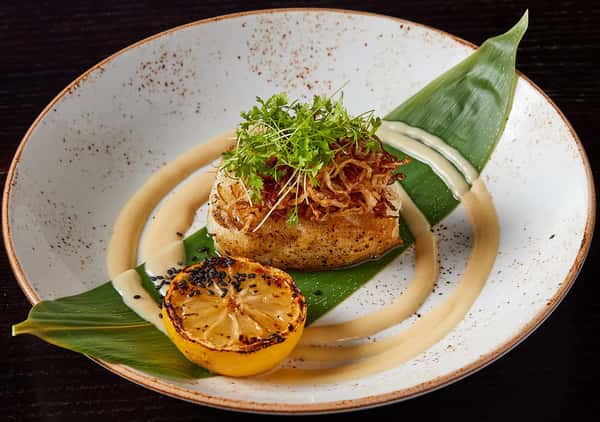entree with orange slice served over leaf garnish