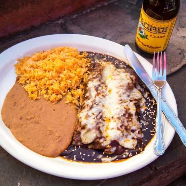 Enchiladas de Pollo con Mole: Chicken enchiladas smothered in mole sauce topped with white cheese. Served with beans and rice