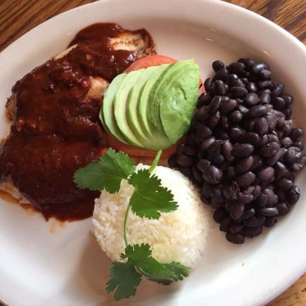 Chicken Mole: Chicken sauteed in mole sauce and sprinkled with sesame seeds. Served with beans, rice, and a tortilla