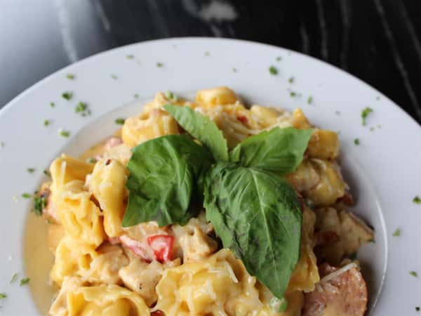 tortellini in a creamy sauce with sausage and peppers