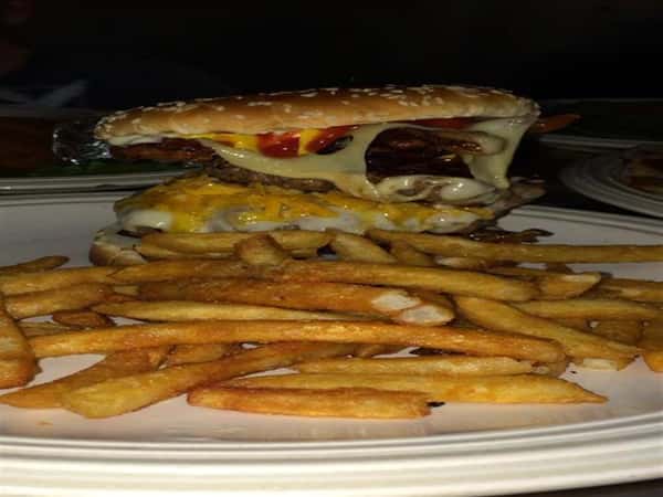 Cheeseburger with onions and ketchup with a side of french fries