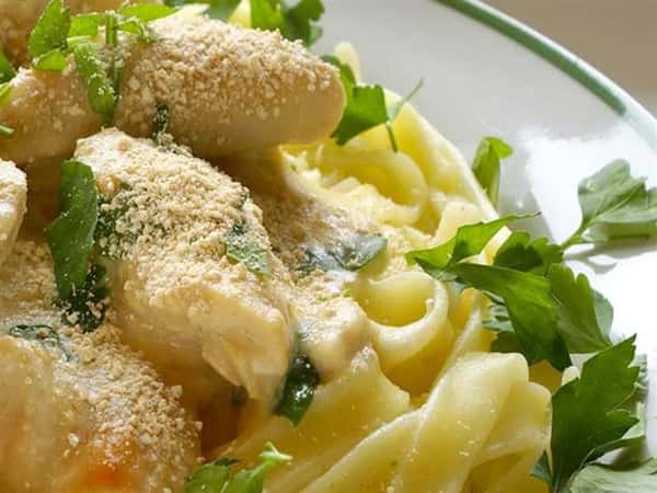 linguine with alreado and chicken breasts garnished with parsley