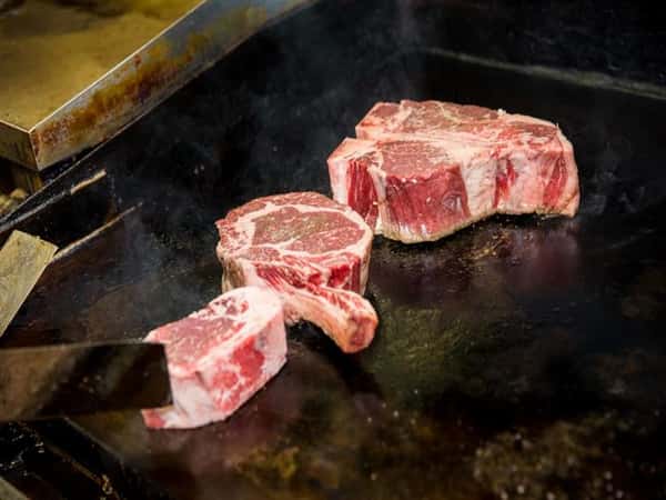 raw steaks on the griddle