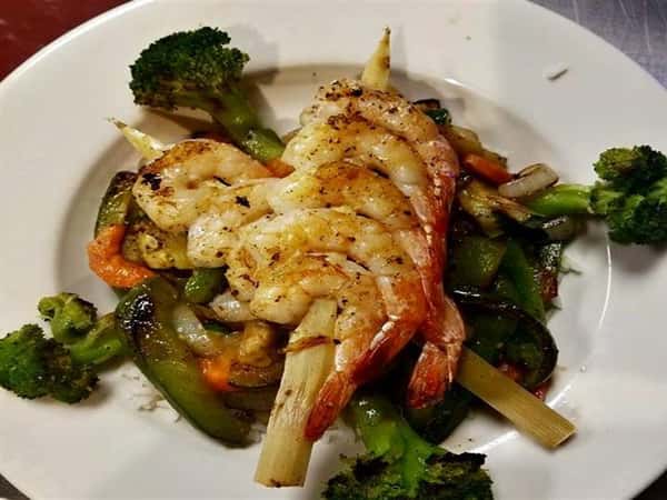 grilled shrimp on top of fresh steamed vegetables