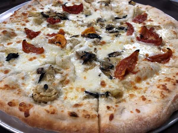 a pizza pie with white cheese, artichoke and red pepper on top