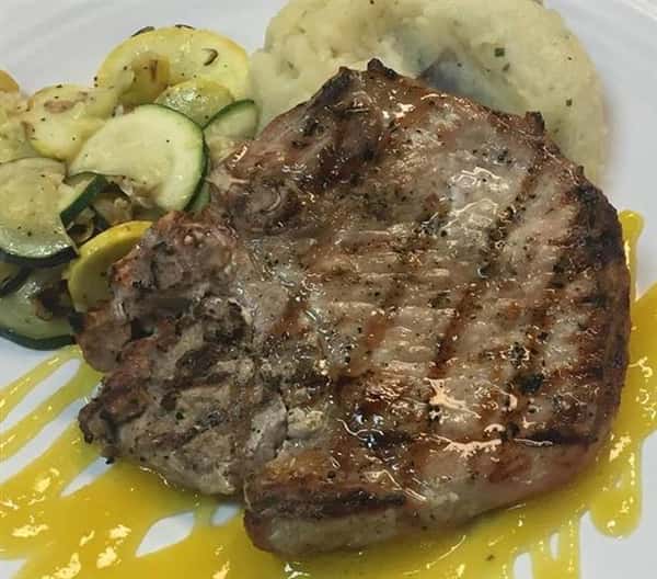 a steak with a side of zucchini and mashed potatoes