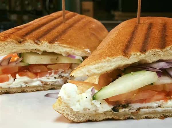 a panini with turkey, tomato, cucumber, red onion