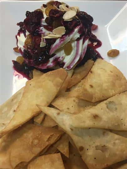 chips with a side of a cream sauce with raisins and nuts