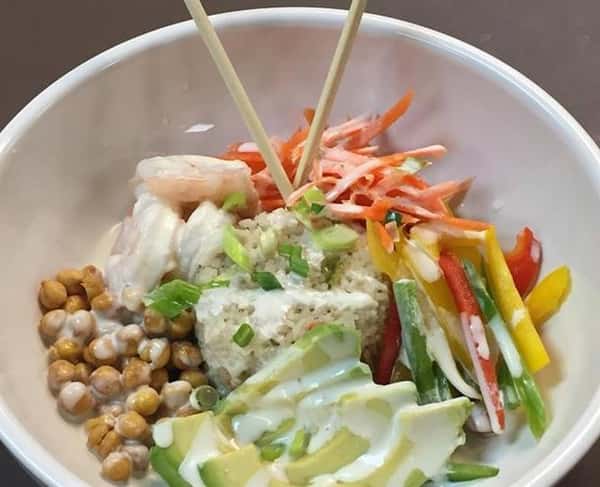 a bowl with white rice, avocado, zucchini, chick peas and carrots
