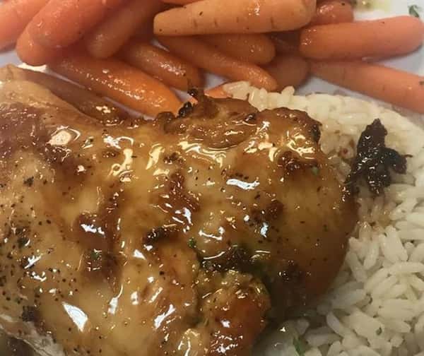 chicken on a bed of rice with a side of baby carrots