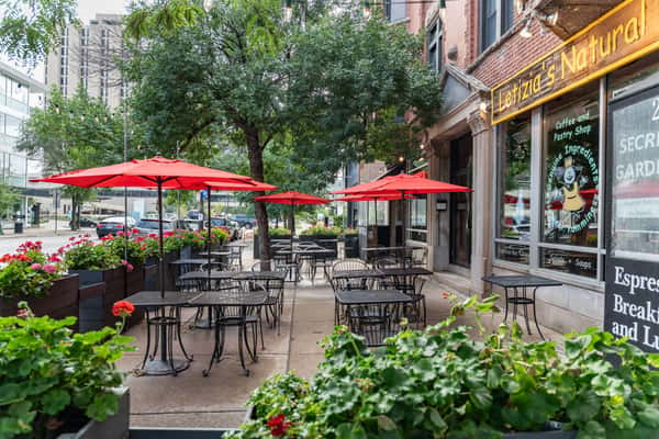 Street view of Enoteca Roma, a traditional Italian restaurant with black awning signage and sidewalk seating — offering authentic Italian dining with a cozy, urban patio ambiance.