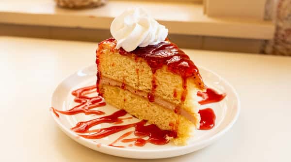 Slice of strawberry cake topped with whipped cream and strawberry sauce at Serafini, an Italian fusion restaurant in historic downtown Frankfort, Kentucky.