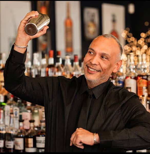 Bartender shaking a handcrafted cocktail behind the bar at Serafini Italian fusion restaurant in downtown Frankfort, Kentucky.