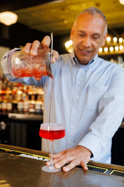 Bartender pouring a handcrafted cocktail at Serafini's full-service bar in downtown Frankfort, Kentucky.