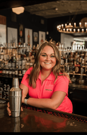 Friendly bartender at Serafini preparing handcrafted cocktails in the welcoming bar of the Italian fusion restaurant in downtown Frankfort, Kentucky.