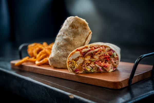 buffalo chicken wrap on top of a wooden plate on a table