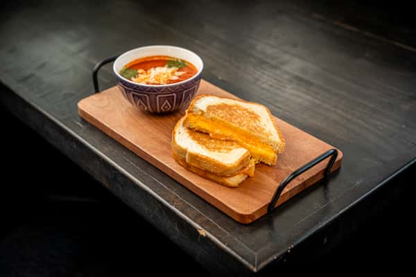 grilled cheese on top of a wooden plate on a table