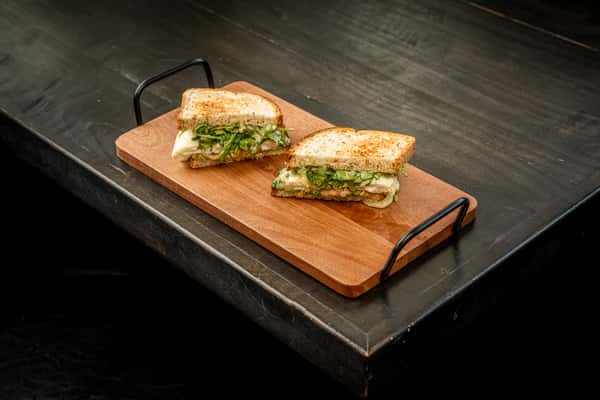 grilled cheese on top of a wooden plate on a table