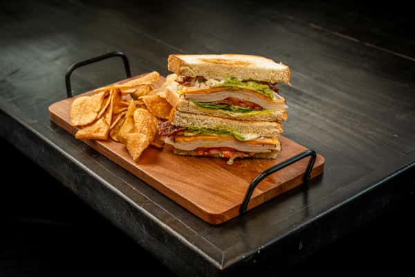blt on top of a wooden plate on a table