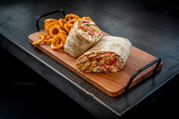 buffalo chicken wrap on top of a wooden plate on a table