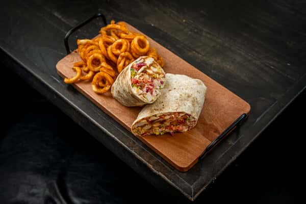 buffalo chicken wrap on top of a wooden plate on a table