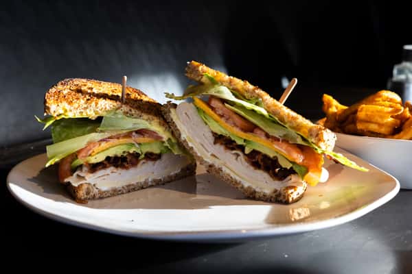 Stacked Sandwich on top of a white plate on a table
