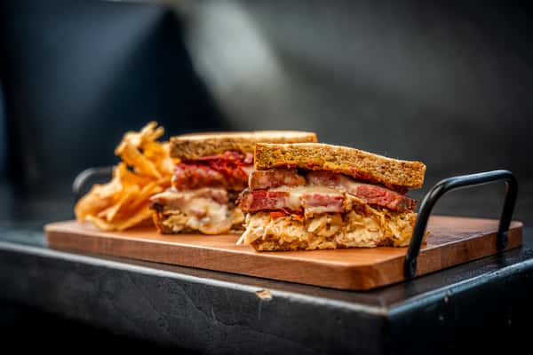 roast beef on top of a wooden plate on a table