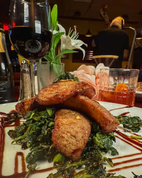 Italian sausage and toasted bread served with sautéed greens at Positano Ristorante Italiano