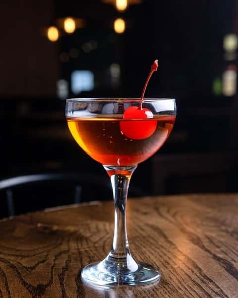 Classic Manhattan cocktail with cherry garnish served at the bar of Positano Ristorante Italiano