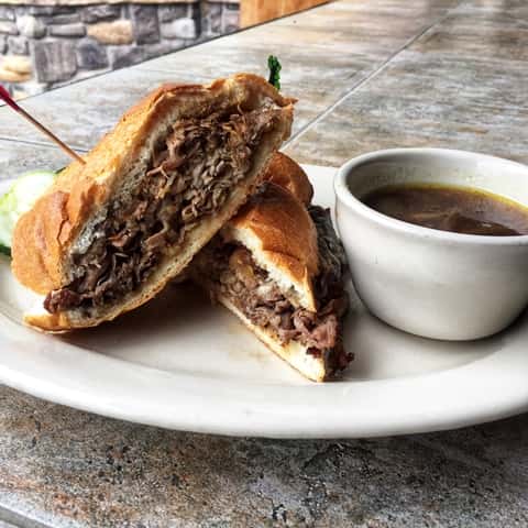 Roast beef sandwich with cheese and aus jus sauce
