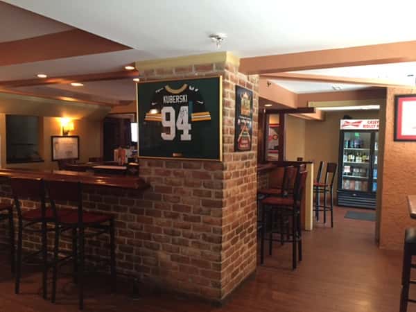Bar with jersey framed on brick wall with fridge in the background