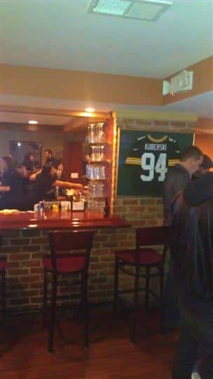 Customers standing in front of the bar with bartenders behind the bar