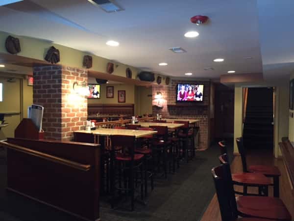 tables and chairs in dining room with a tv on the wall