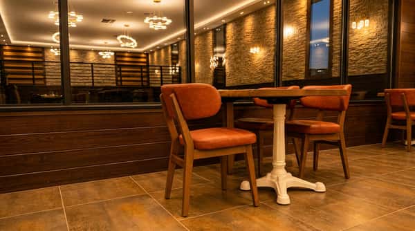 Restaurant interior with brown leather chairs, dark wood tables, striped wood walls, and a stone accent wall.