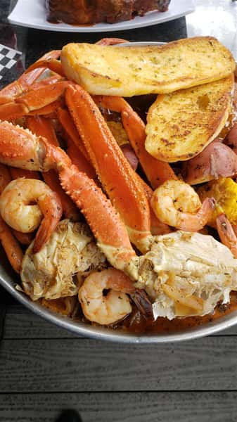 A bowl filled with seafood such as crab legs and shrimp