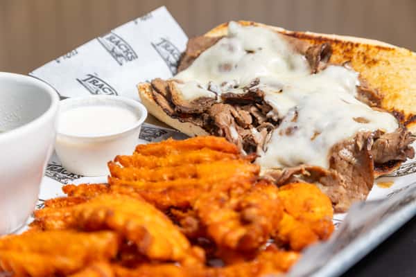 Philly cheesesteak sandwich with sweet potato waffle fries
