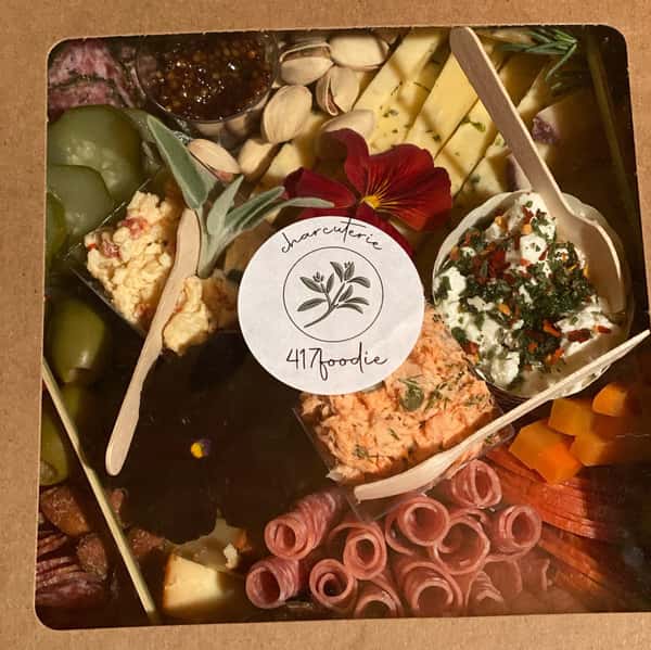 charcuterie board with assorted meats, cheeses, fruits, vegetables and nuts in a box