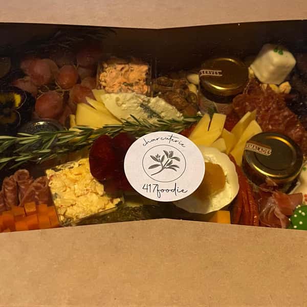 charcuterie board with assorted meats, cheeses, fruits, vegetables and nuts in a box