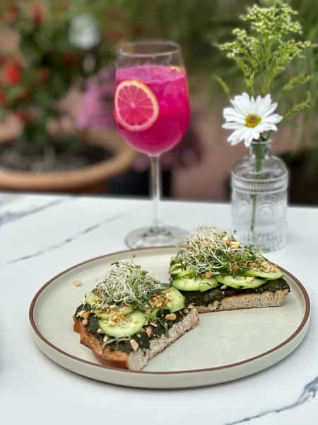open faced cucumber sandwich with pink cocktail
