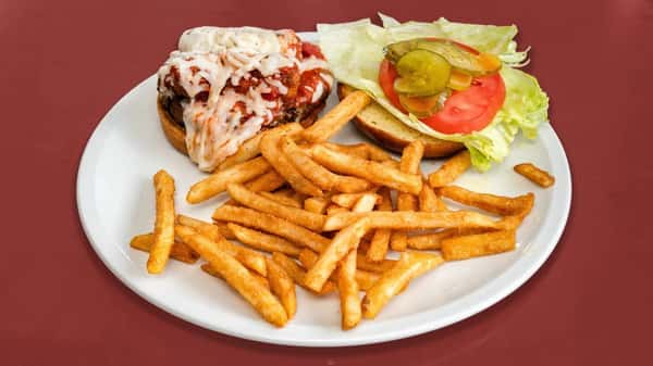 Open-faced meatball sub burger topped with marinara and melted mozzarella, served with fries, lettuce, tomato, onion, and pickles.