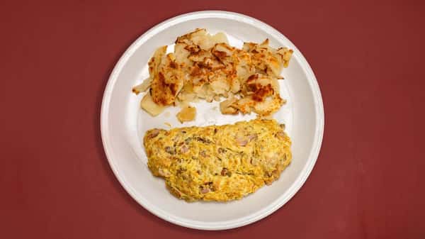 A hearty breakfast plate featuring a golden-brown omelet filled with ingredients like ham and vegetables, served alongside crispy, well-browned hash browns. Classic diner comfort food!