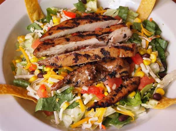 salad with lettuce, tomatoes, beans, cheese and grilled chicken