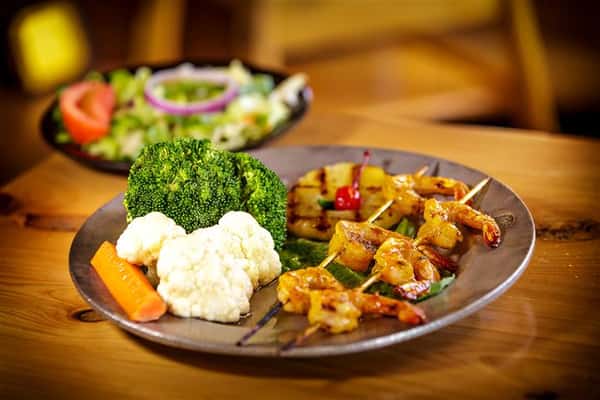 shrimp skewers with vegetables and pineapple slices