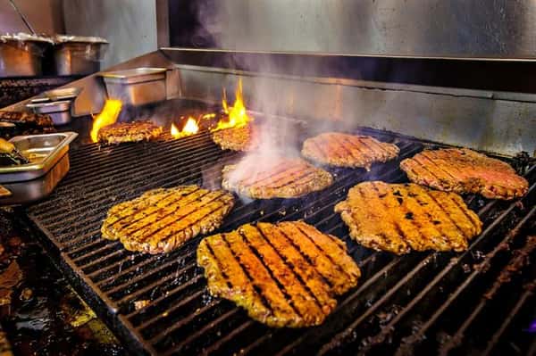 burgers on a fire grill being cooked