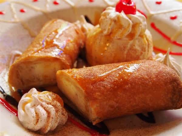 pastries on a plate topped with whipped cream and a cherry