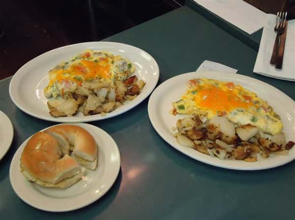 Bagel with omelettes and hashed potatoes on a platter