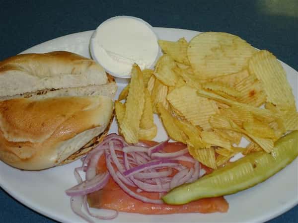 Butter roll with a side of chips and a pickle slice